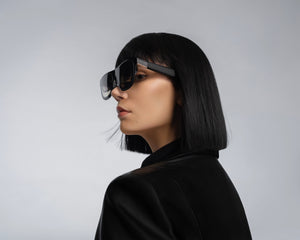 Person wearing futuristic sunglasses with a plain background