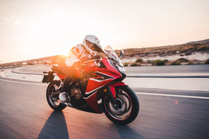 Person riding motorcycle with glasses underhelmet