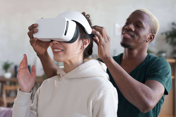 A man helping a woman try virtual reality