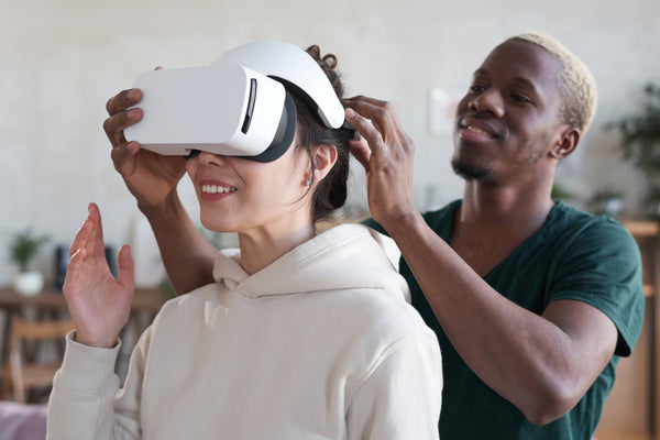 A man helping a woman try virtual reality