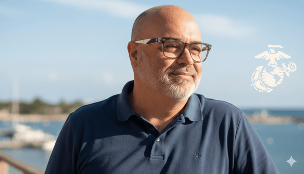 Man wearing glasses and a dark blue shirt with a blurred background