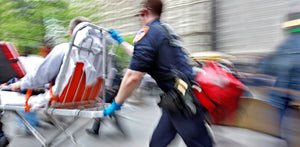 Person in uniform pushing a stretcher with an injured person on it, blurred motion.