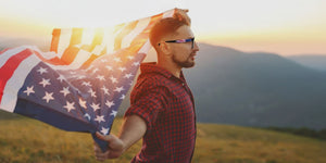 Man holding an American flag with a scenic background