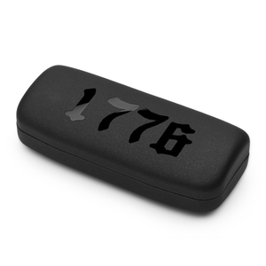 Black rectangular eyeglass case with object with '1776' engraving on a white background
