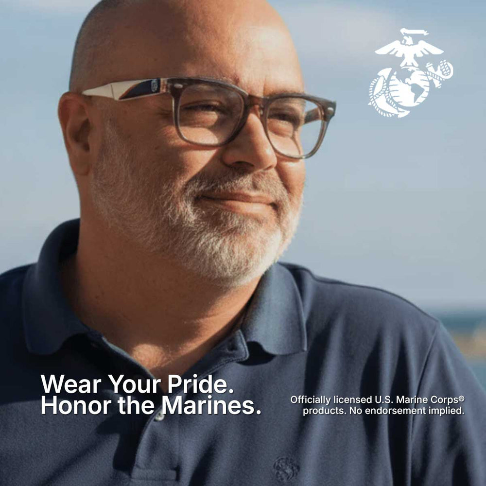 Man wearing glasses and a navy shirt with U.S. Marine Corps logo and text.