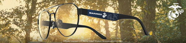 Glasses with 'Marines' logo against a blurred forest background