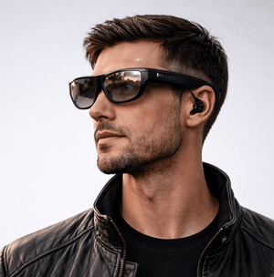 Man wearing XREAL VR glasses and a black jacket with a neutral background